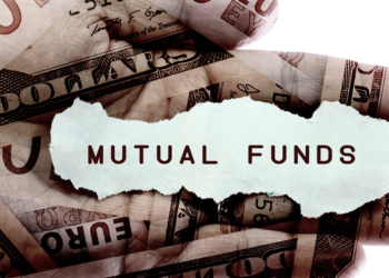 A photograph depicting a wooden box filled with neatly arranged stacks of papers, labeled 'Mutual Funds.' In the background, a European currency note can be seen, hinting at the financial context. The image symbolizes the concept of investing and financial management in mutual funds.